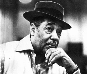 Duke in hat, with chin on his hand