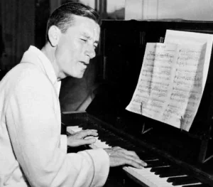 hoay carmichael sitting at a pinao with sheet music